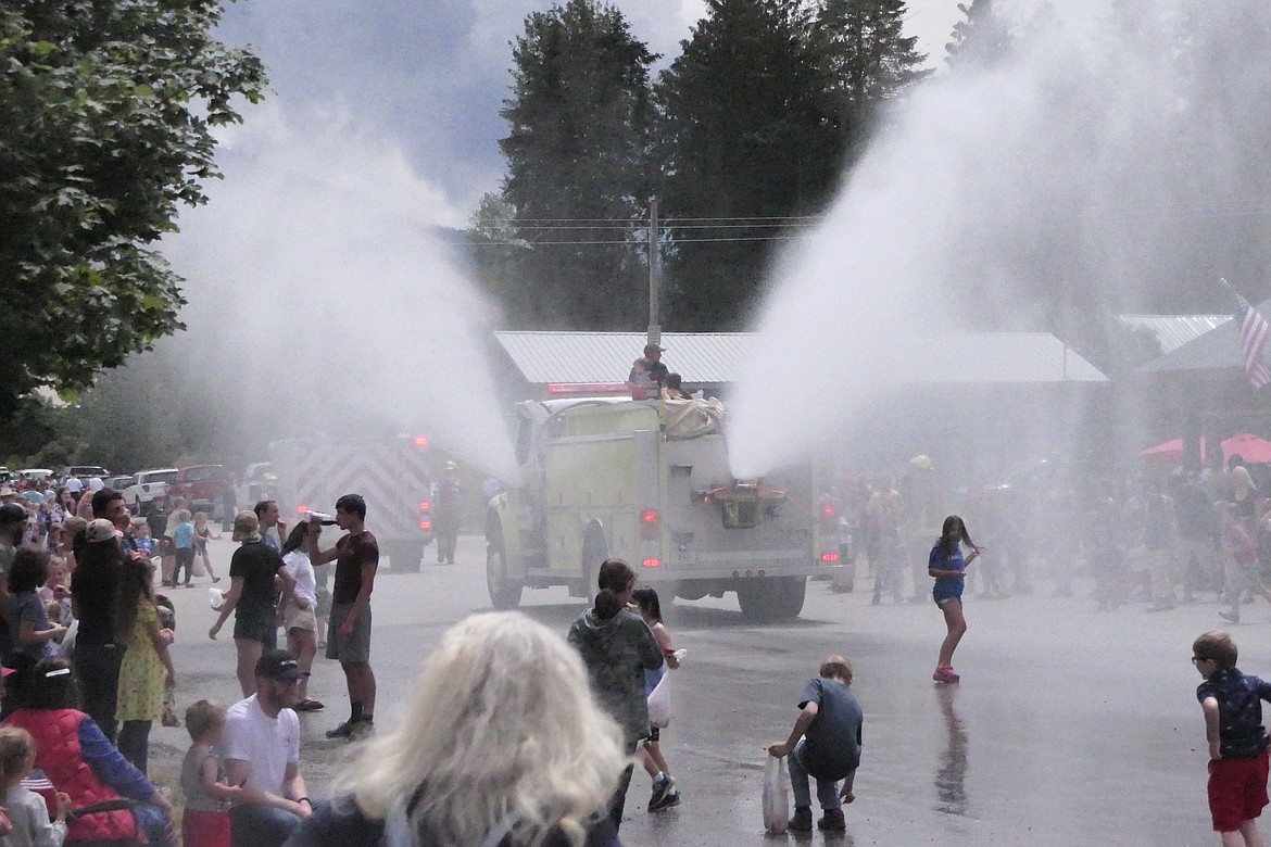 A spray of cooling mist from local firefighters helped cool the streets and people who watched this year's Fourth of July celebration in Noxon.  (Chuck Bandel/VP-MI)