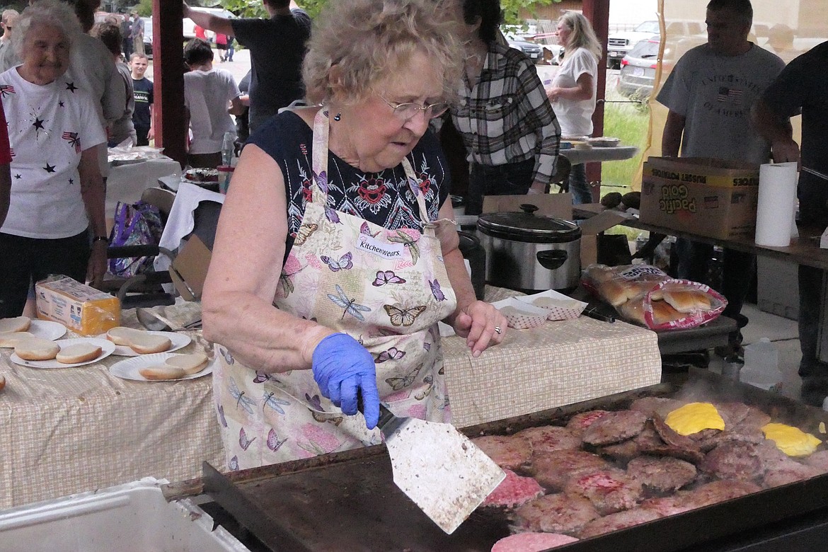 Noxon resident Joyce Byler tends to hamburgers and cheeseburgers to help feed a large group in Noxon's waterfront park during this year's 4th of July celebration.  (Chuck Bandel/VP-MI)