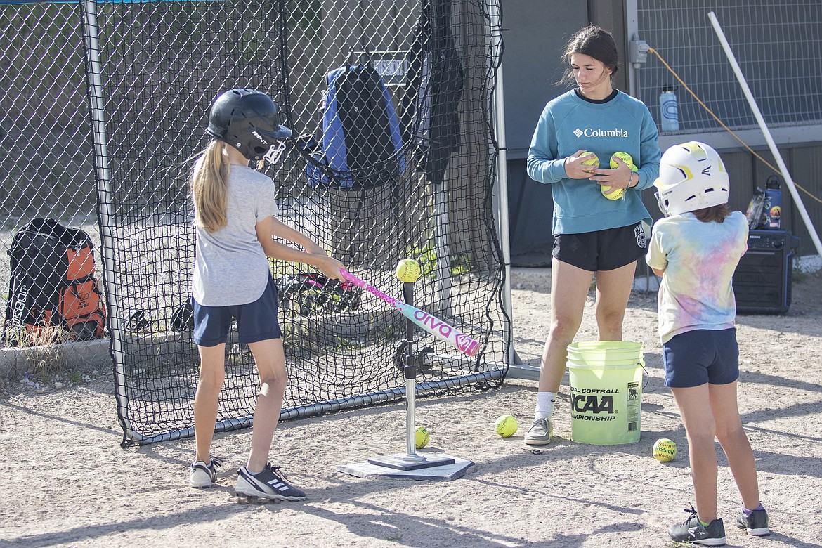 A youngster works on her batting technique under the watchfull eye of MAC Lady Bulldog Cassidy Orr. (Rob Zolman/Lake County Leader)