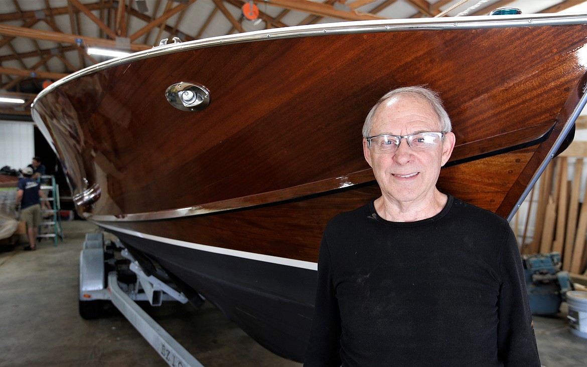 Syd Young stands by a 35-foot wooden boat he and his crew builts at Dreamboats, Young's newest venture.