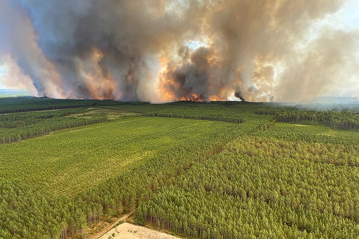 This photo provided by the fire brigade of the Gironde region (SDIS33) shows a wildfire near Landiras, southwestern France, Wednesday, July 13, 2022. More than 800 firefighters battled two wildfires in southwest France, according to the regional emergency service. The fires began Tuesday near the towns of Landiras and La Teste-de-Buch, and firefighters had not been able to contain them by Wednesday morning. Some 6,500 people have been evacuated from campgrounds and villages in the forested area. (SDIS33 via AP)
