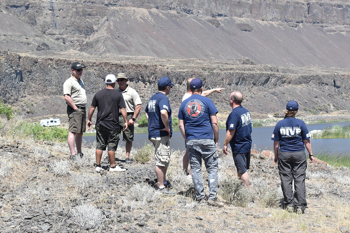 Members of Columbia Basin Dive Rescue talk with Grant County Sheriff’s Office deputies and a member of the missing man’s family to make a plan on where to search first.