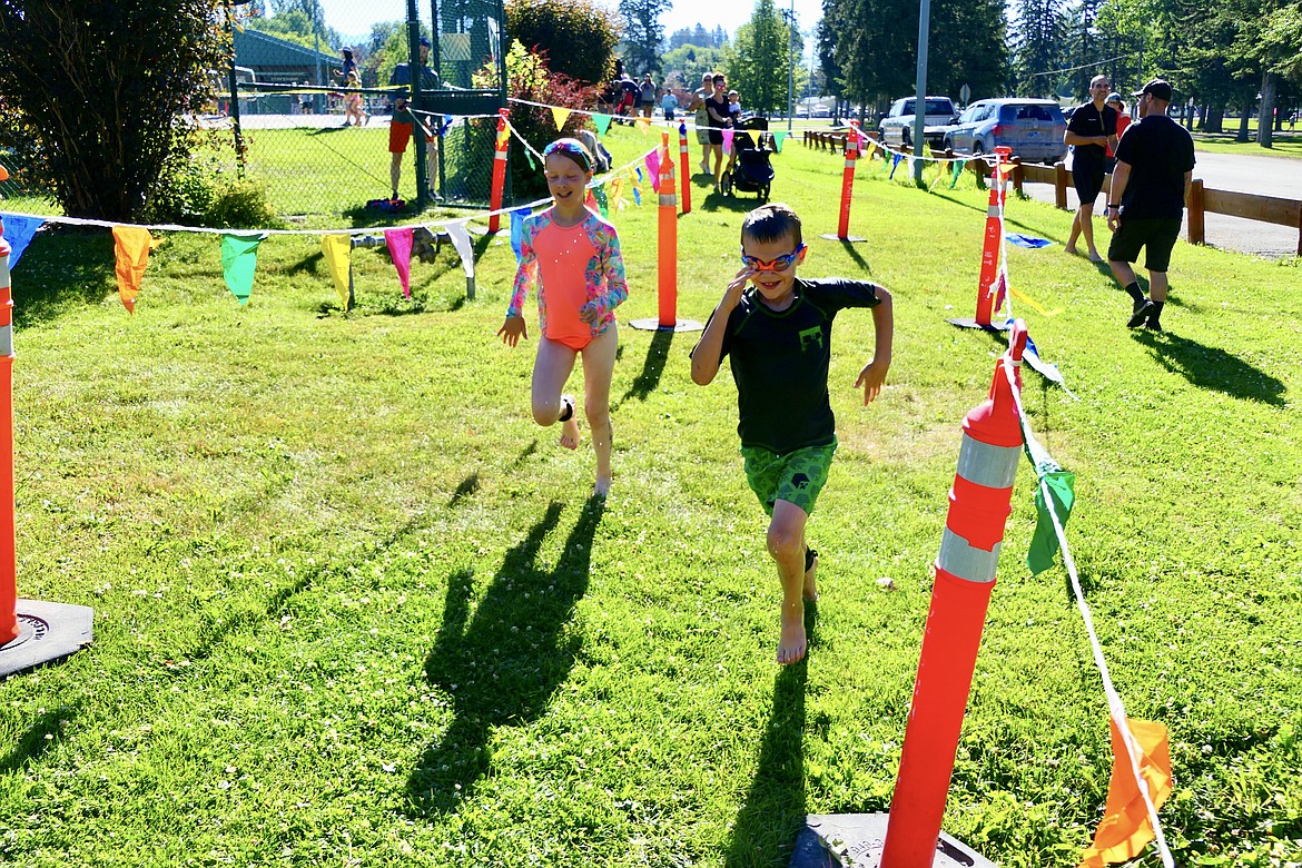Competitors transition from the swim to the bike portion of the Logan Health Kids Triathlon at Woodland Park in Kalispell on Saturday, July 16. (Matt Baldwin/Daily Inter Lake)