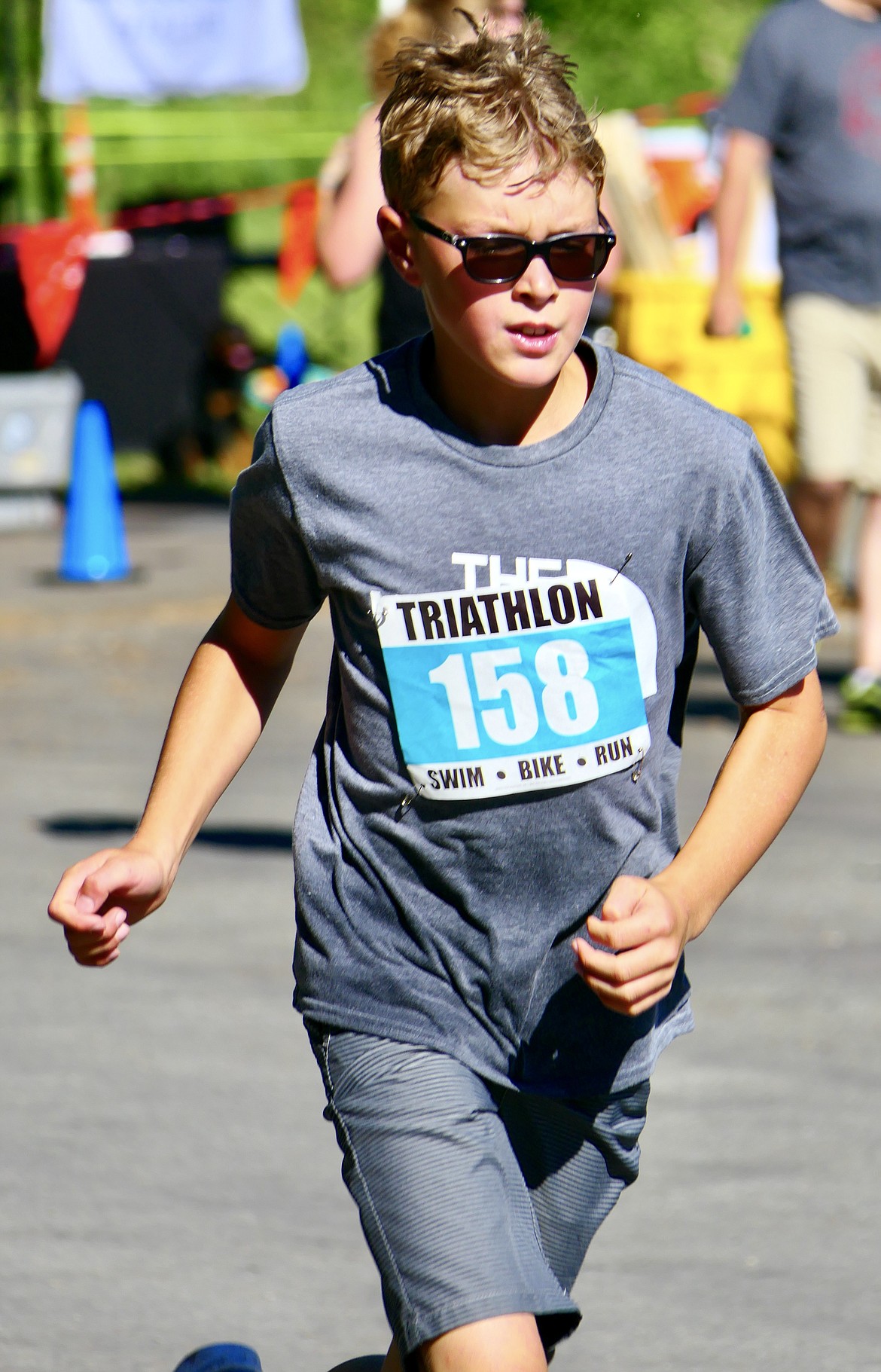 Robby Schuttler, 10, runs toward the finish line of the Logan Health Kids Triathlon at Woodland Park in Kalispell on Saturday, July 16. (Matt Baldwin/Daily Inter Lake)