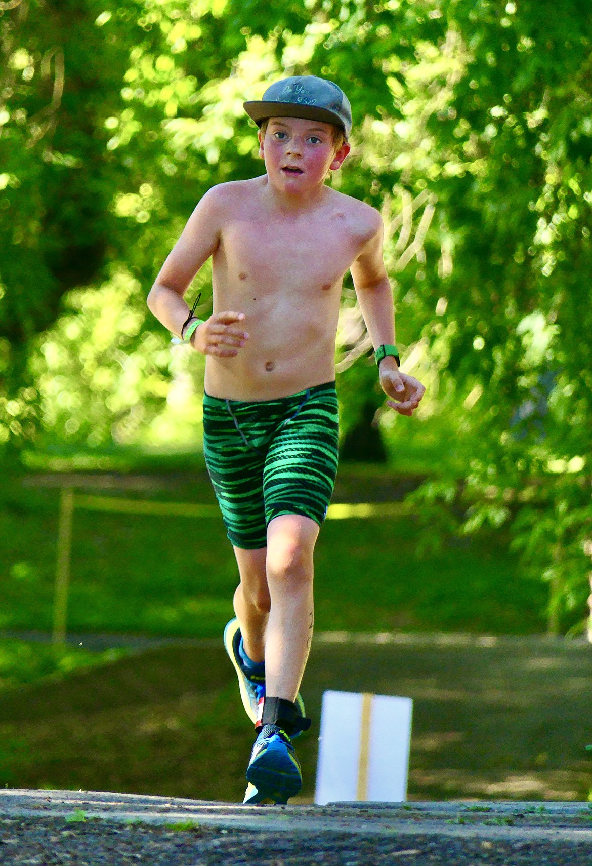 Porter Shehan, 11, approaches the finish of the Logan Health Kids Triathlon at Woodland Park in Kalispell on Saturday, July 16. Sheehan, of Whitefish, finished second overall in his age group. (Matt Baldwin/Daily Inter Lake)