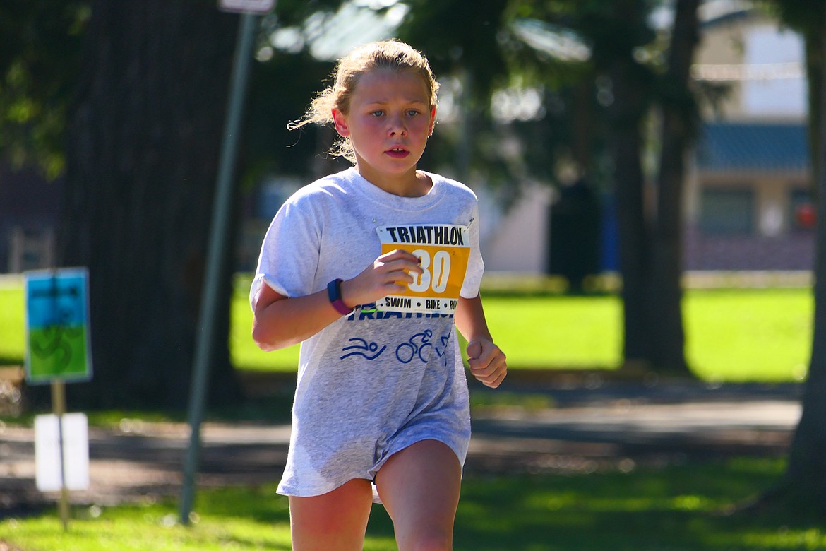 Ember Dyck, 8, competes in the Logan Health Kids Triathlon at Woodland Park in Kalispell on Saturday, July 16. Dyck, of Kalispell, placed first in her age group. (Matt Baldwin/Daily Inter Lake)