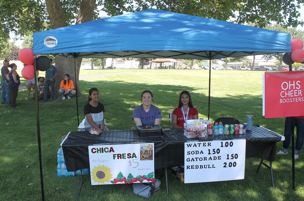 From left: Juliza Gonzalez, Naylene Garza and Mariz Gonzalez offer cold pop, water and other beverages to the attendees at the Othello All-City Classics car show Saturday.