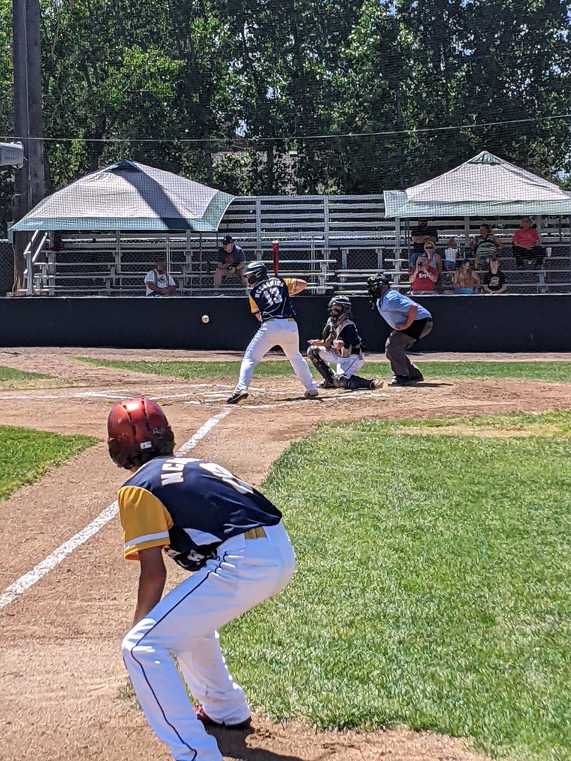 Riverdogs' Bryson McCormick swings at a pitch while Trenis McDonald leads off third base in the Riverdogs 18-2 win over Butte last week in a tournament in Belgrade. (Jon Zigler photo)