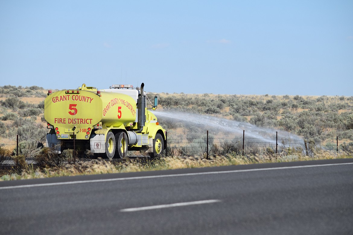 A truck sprays water where a fire broke out between Ephrata and Moses Lake on Monday. An incident commander at the scene said firefighters were lucky that a gravel road acted as a firebreak to prevent multiple fires from spreading.