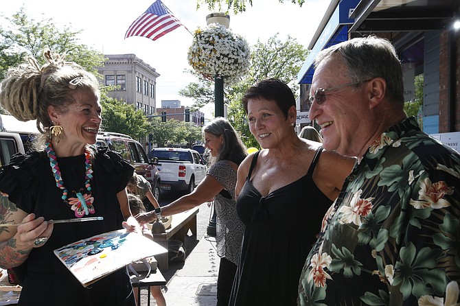 Artist Michelle Allen and Mix It Up owner Beth Brown chat with a customer during July’s Artwalk.