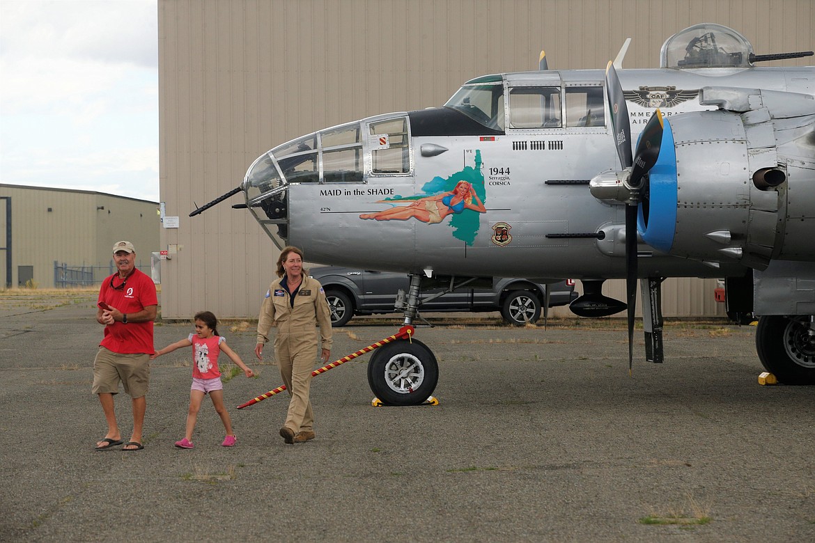 A crew member and guests walk away from the B-25, "Made in the Shade," on Monday at the Coeur d'Alene Airport.