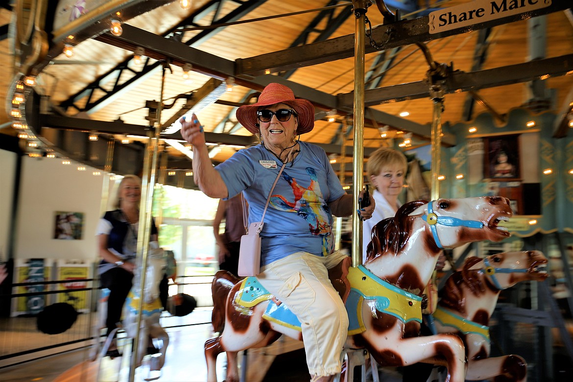 Cheryl Miller tosses a ring while riding the Coeur d'Alene Carousel.