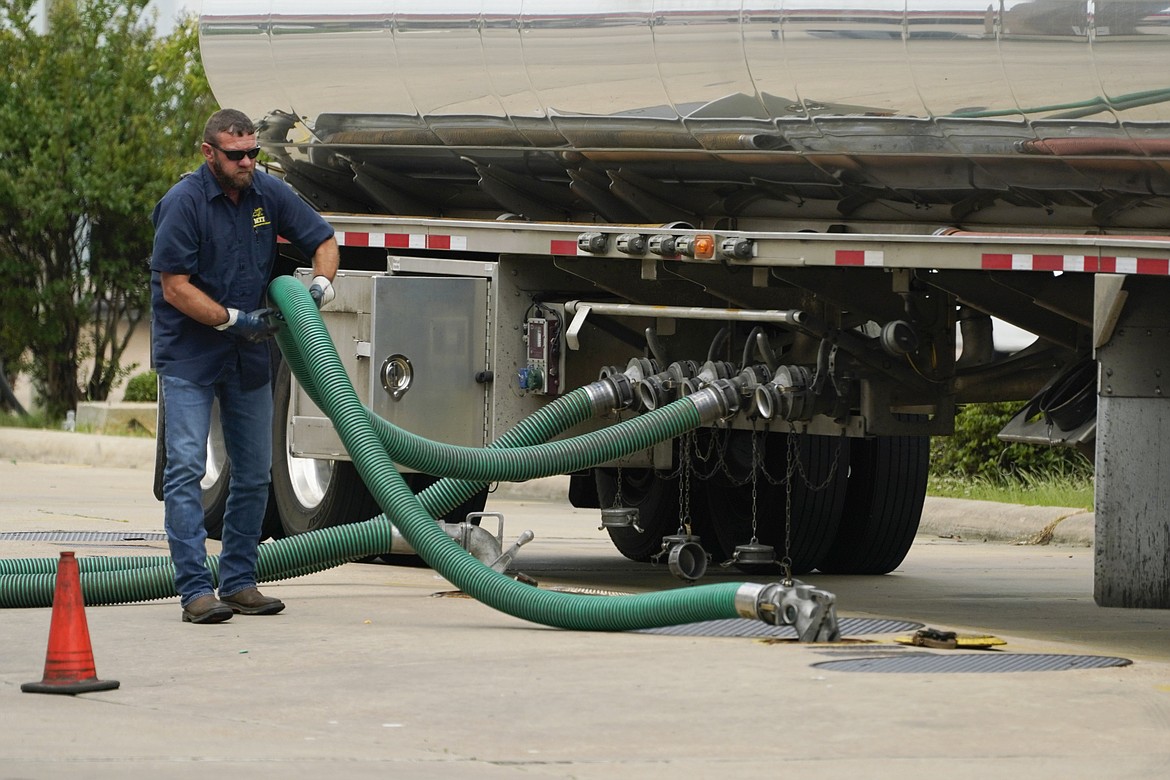 A gas tank driver adjusts his hose hookup to an underground tank on May 24, 2022, in Jackson, Miss. High diesel prices are driving up the cost of most goods, from groceries to Amazon orders and furniture, as nearly everything that is delivered, whether by truck, rail or ship, uses diesel fuel. Truckers are turning down hauling jobs in the states with the most expensive diesel. (AP Photo/Rogelio V. Solis, File)