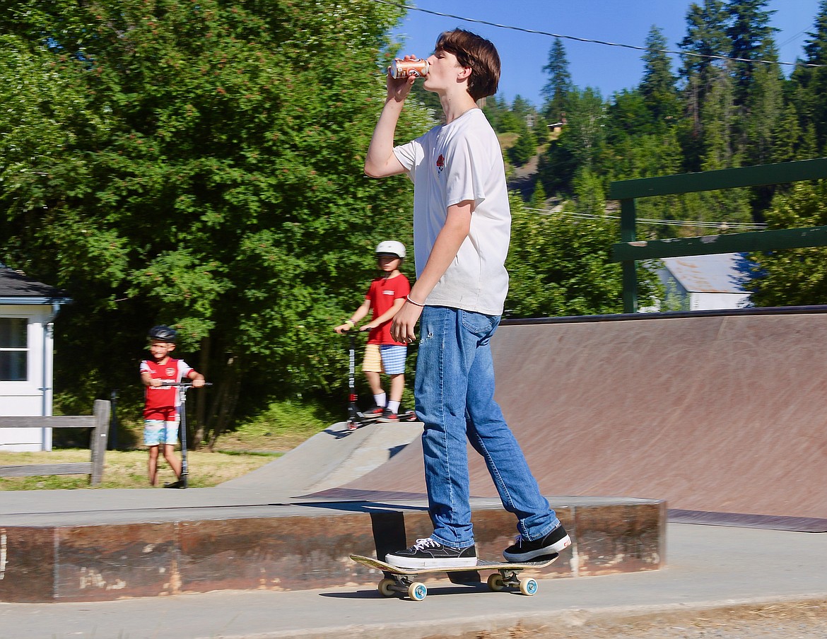 Skateboarding shows off balance by drinking and boarding.
