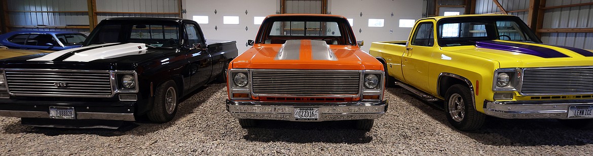 Three Chevy pickups in the collection of Donny Stevens, black 1977, Orange 1973 and Yellow 1978 models. (Jeremy Weber/Daily Inter Lake)