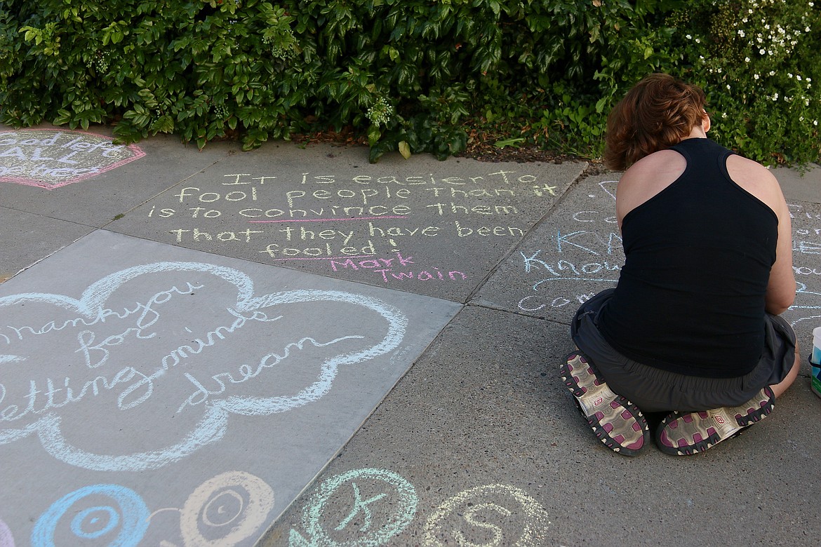 Community member adds to the chalk art and notes of support for the library staff, director and board. 
The Mark Twain quote reads "It is easier to fool people than it is to convince them that they have been fooled."
