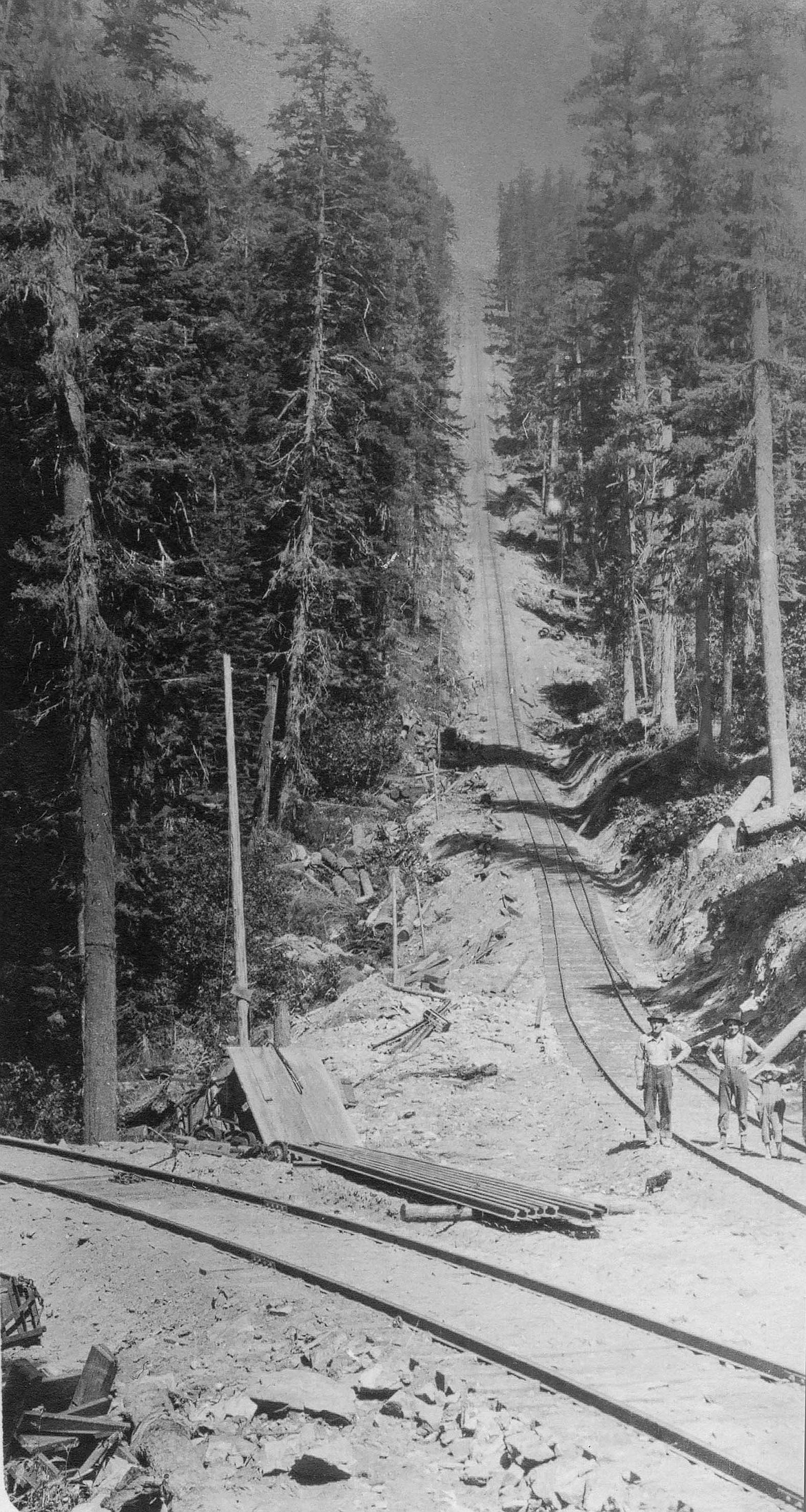 Three people stand at the bottom of the Incline railroad near Clarkia, Idaho.