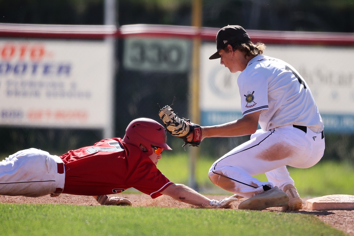 Glacier Twins first baseman Stevyn Andrachick puts the tag on Cranbrook runner Ryan White to complete a pickoff play at the Western A district tournament in Kalispell on Thursday, July 21. (Jeremy Weber/Daily Inter Lake)