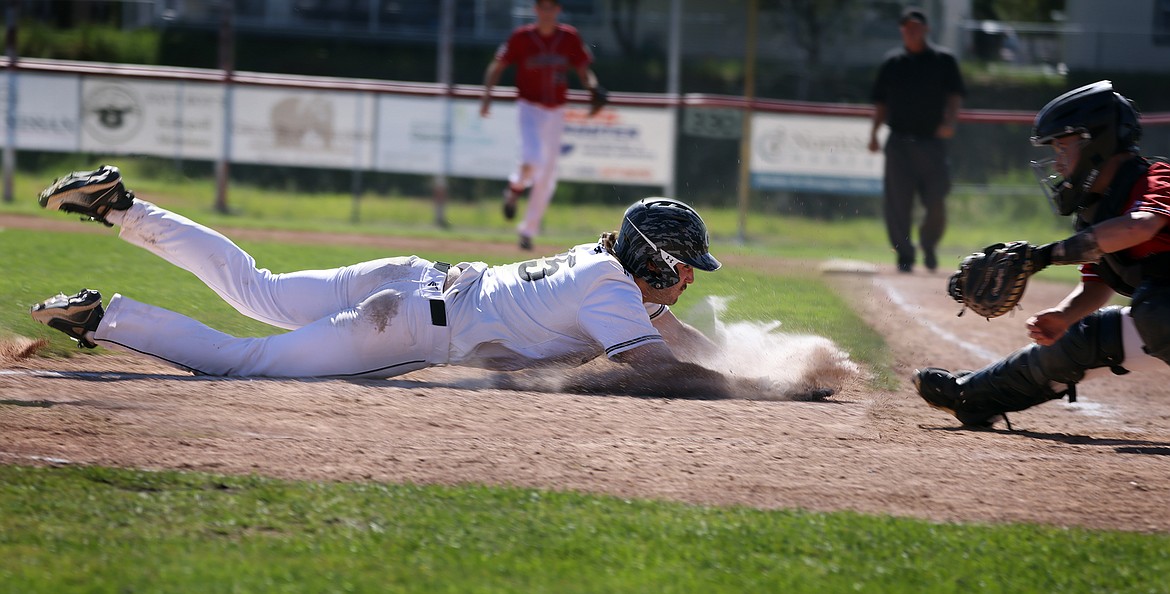 Glacier runner Owen Shilling makes a diving attempt to score in the Twins 13-3 win over Cranbrook in the American Legion West A District Tournament in Kalispell on Thursday, July 21. (Jeremy Weber/Daily Inter Lake)