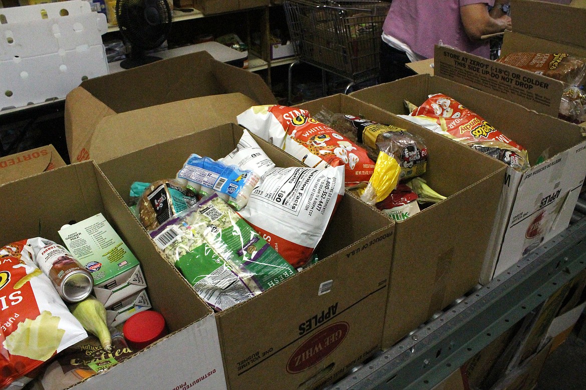 Boxes of food await distribution at the Royal City Food Bank Tuesday. The packages include bread, milk, canned soup and soup mixes and, for a treat, a bag of Cheetos.