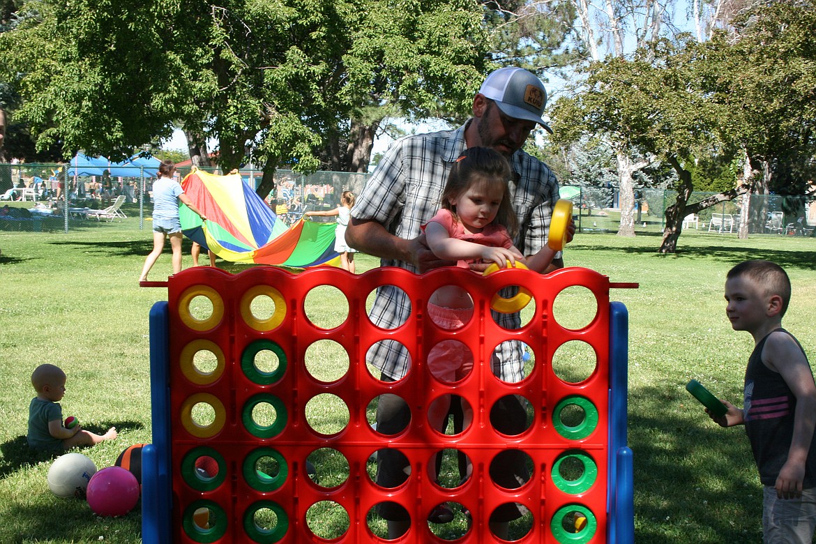 With the help of her dad Logan Dunn, Sadie Dunn plays the connect the dots game that’s part of the mobile recreation van sponsored by the Moses Lake Parks, Recreation and Cultural Services Department.