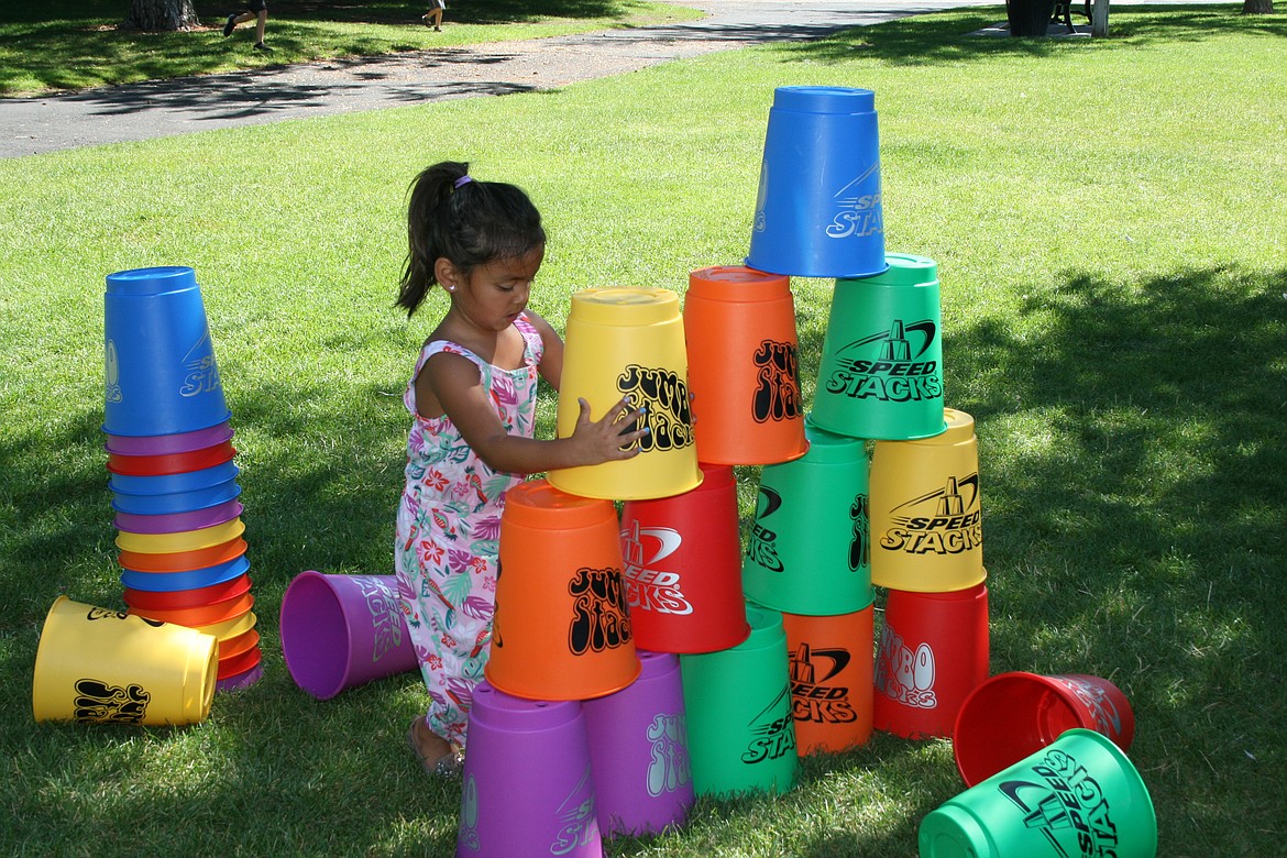 Kamila Montes stacks the cups, ready to knock them down, one of the games on offer in the mobile rec van.