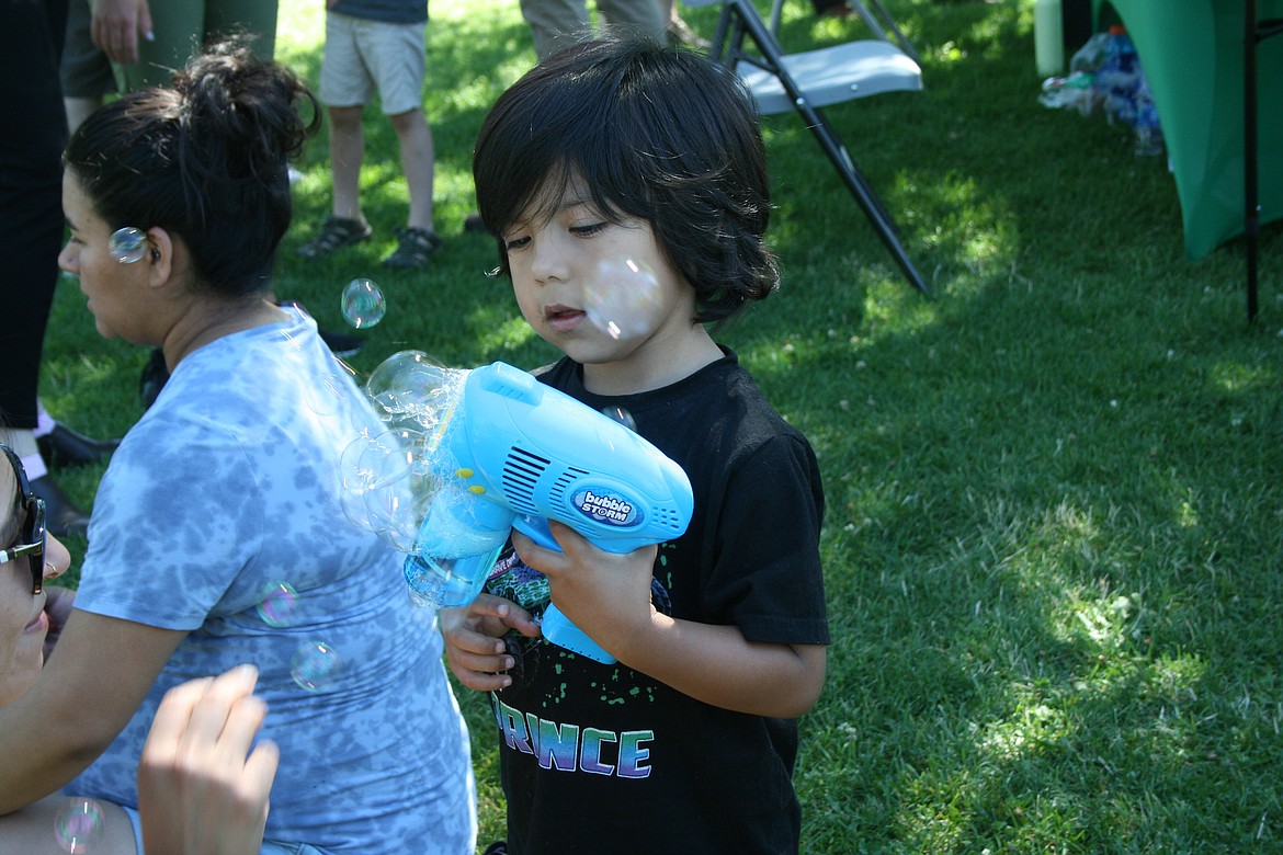 Prince Bruno explores the bubble gun. Bubbles, stackable cups and card games are among the fun games on the city of Moses Lake’s mobile rec van.