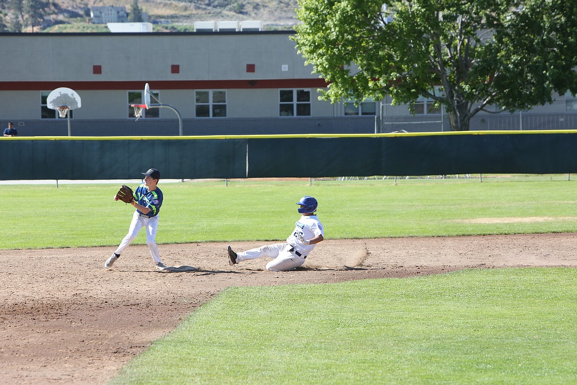 A Riverdog slides into base as an opposing player keeps an eye out for the ball. Pool play begins on Sunday for the 13U Riverdogs and Monday for the 15U Riverdogs.