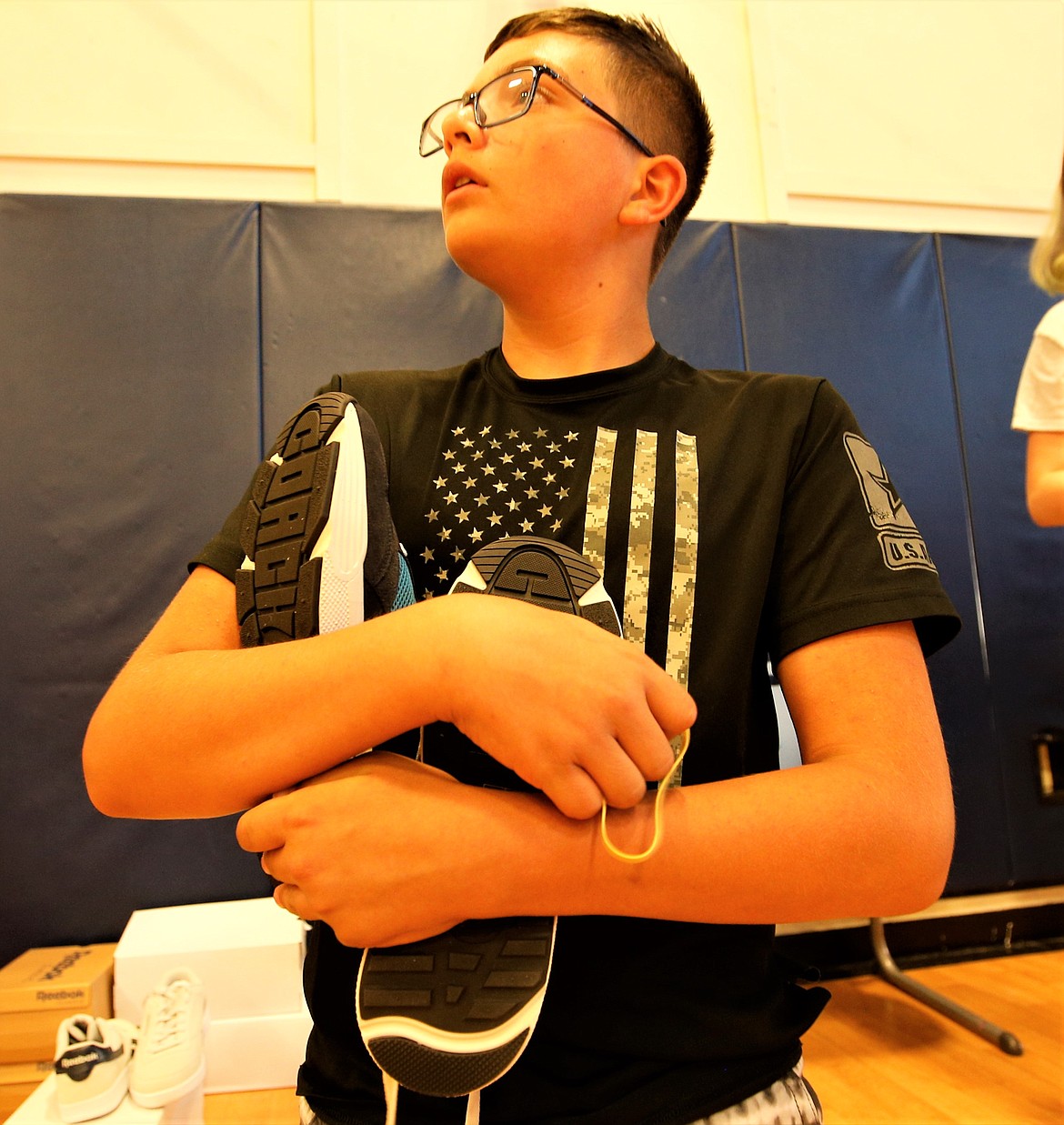 Kegan Strange holds the shoes he selected at the Lola and Duane Hagadone Boys and Girls Club of Kootenai County on Thursday.