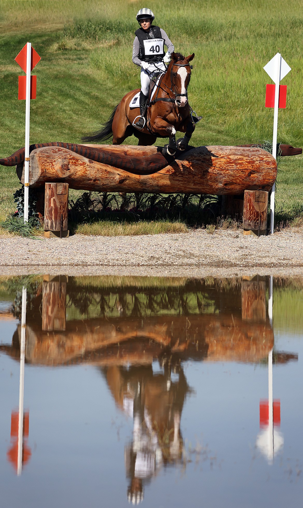 Lucienne Bellissimo rides her horse "Caitane Z" through the first water feature at The Event at Rebecca Farm July 23. (Jeremy Weber/Daily Inter Lake)
