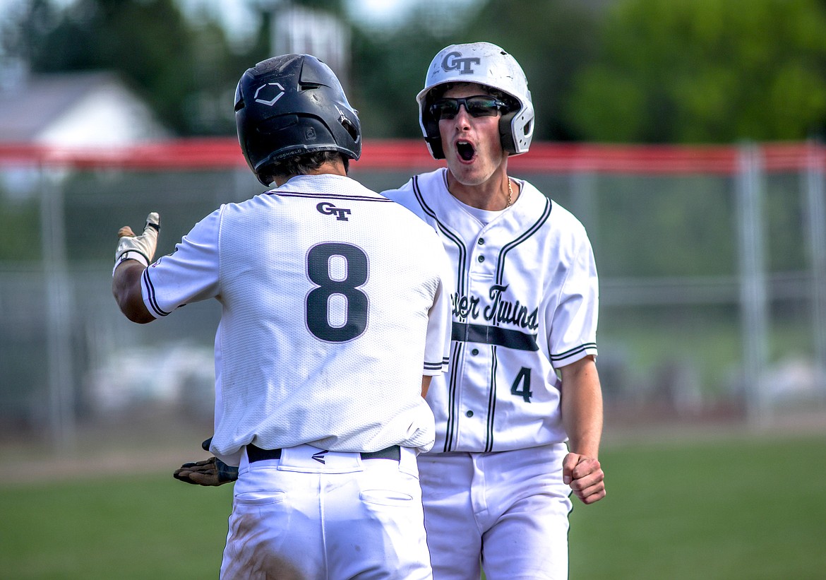 Mason Peters and Hayden Meehan celebrate after they both scored a run on Friday during the West A District Legion baseball tournament in Kalispell. (JP Edge photo)