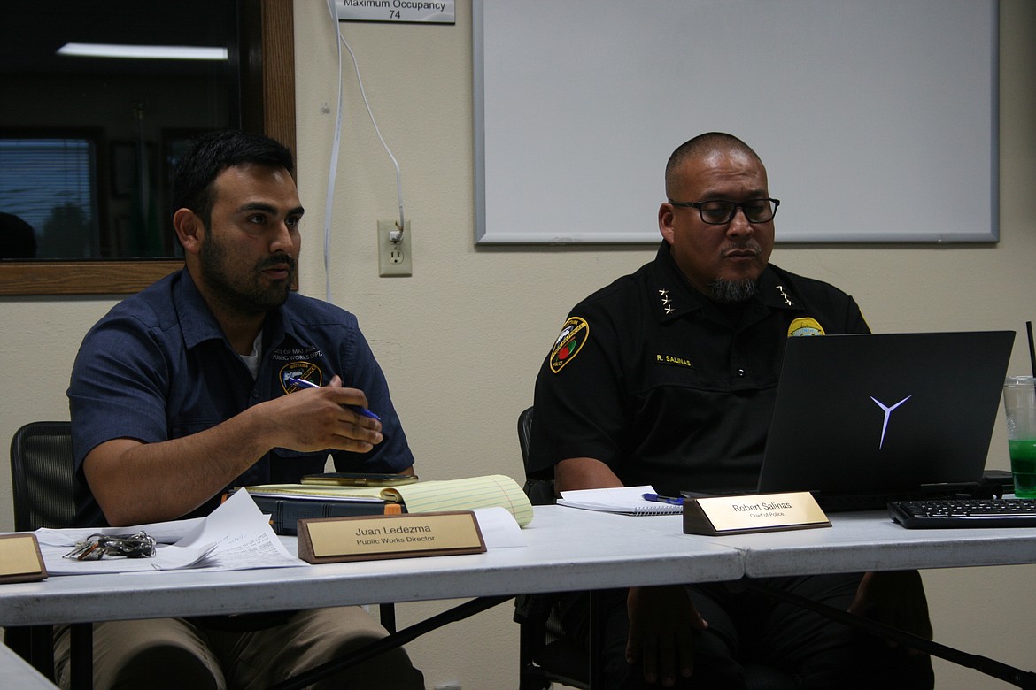 Mattawa Public Works Director Juan Ledezma, left, discusses the cost of dog control during the July 21 Mattawa City Council meeting while Mattawa Police Chief Robert Salinas, right, listens.