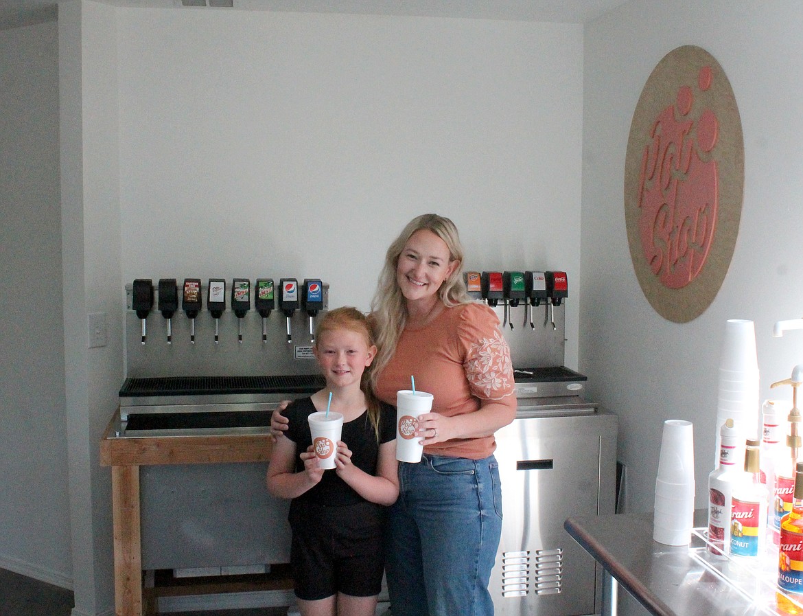 Kelsey Edwards, right, stands with her daughter, 9-year-old Cozette Edwards, in the front area of Pop Stop on Thursday. Edwards is opening the shop with her friend and business partner Allie Earl. Cozette is enjoying one of Pop Stop’s specialty beverages, Sprite with watermelon, peach and strawberry.