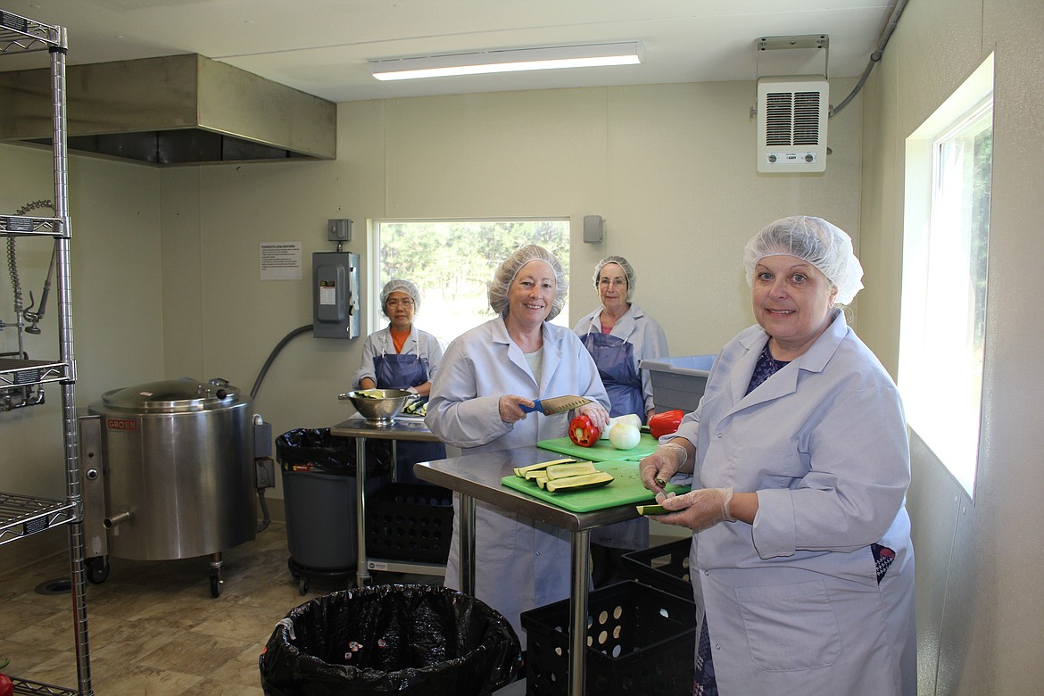 From left, Mariel Mattox, Diane Metzger, Mary Ippisch and Resa Briscoe (missing is Cassidy Goins) hand chop fresh ingredients for a batch of organic zucchini relish that Ippisch started making in the 1970s. Her kitchen is in Superior, and she averages about one batch a month between April and October. (Monte Turner/Mineral Independent)