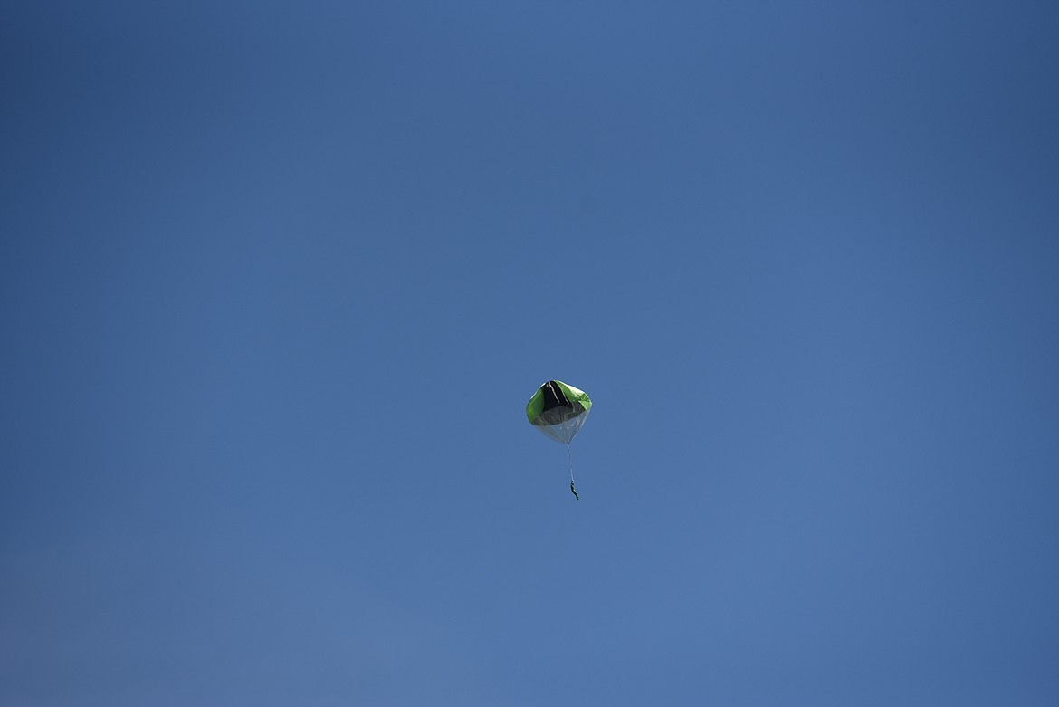 A parachute model drops from a remote control plane operated by Ron Anderson on Saturday, July 23, 2022, at the Kootenai RC Flying Field on Champion Haul Road. The airstrip was built in 2010 in a joint effort with the U.S. Army Corps of Engineers. (Scott Shindledecker/The Western News)