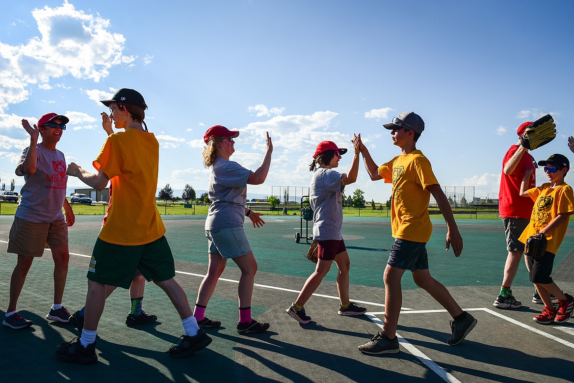 Players from the Angels Grey and Pirates teams slap hands at the end of a Miracle League of Northwest Montana game at Kidsports Complex on Tuesday, July 27. (Casey Kreider/Daily Inter Lake)