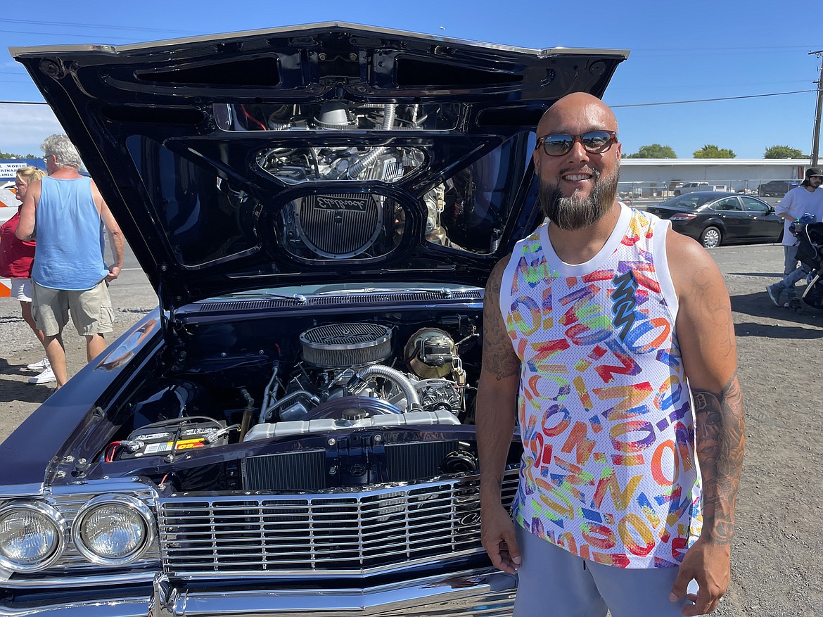 Derek Martinez with his customized 1964 Chevrolet Impala lowrider, complete with mirrors on the underside of the hood.