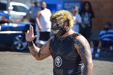Lucha Libre wrestler Black Danger signals to the crowd as he walks out to face El Quete in the ring during an exhibition of Mexican-style professional wrestling in Moses Lake on Saturday.