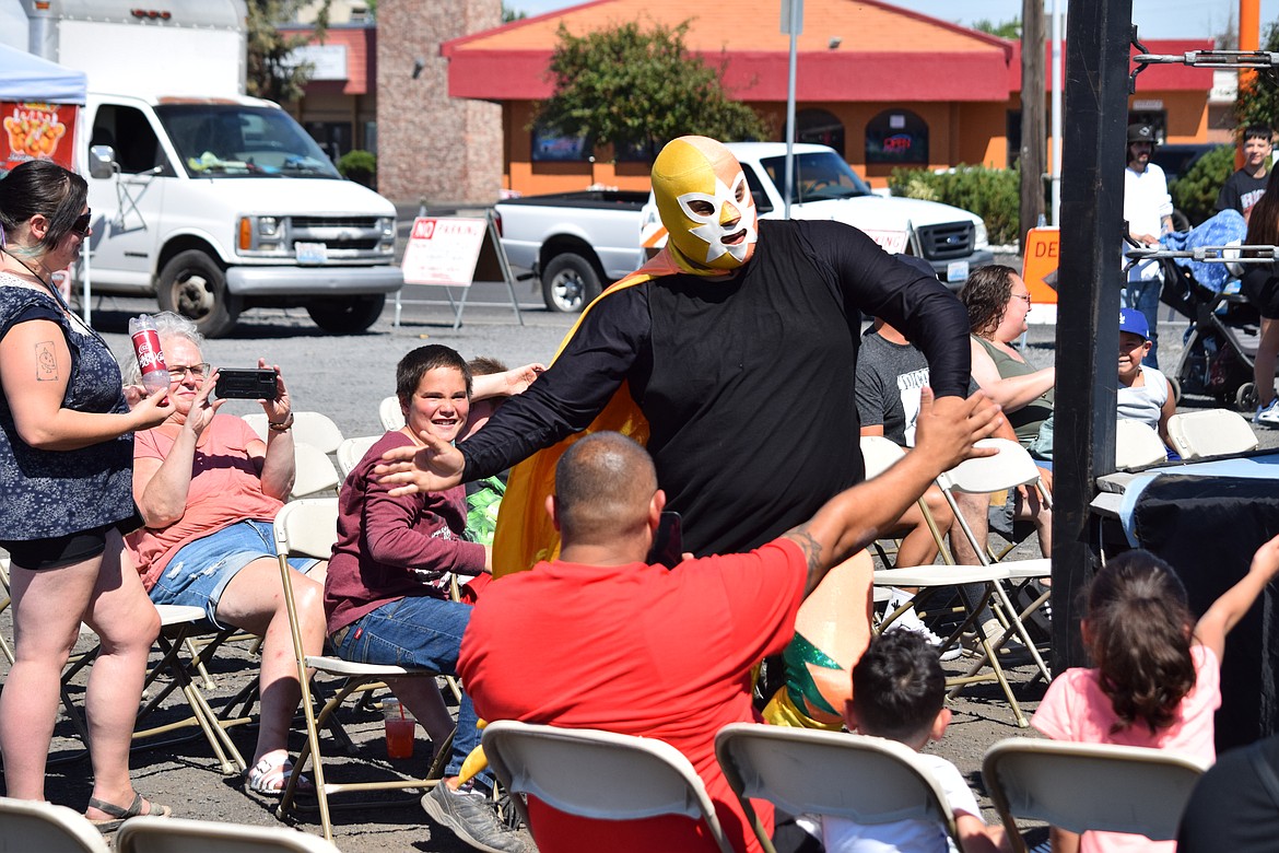 Lucha Libre wrestler El Quete high fives and fist bumps with the crowds prior to his match at the EDUBB C/S grand opening on Saturday.