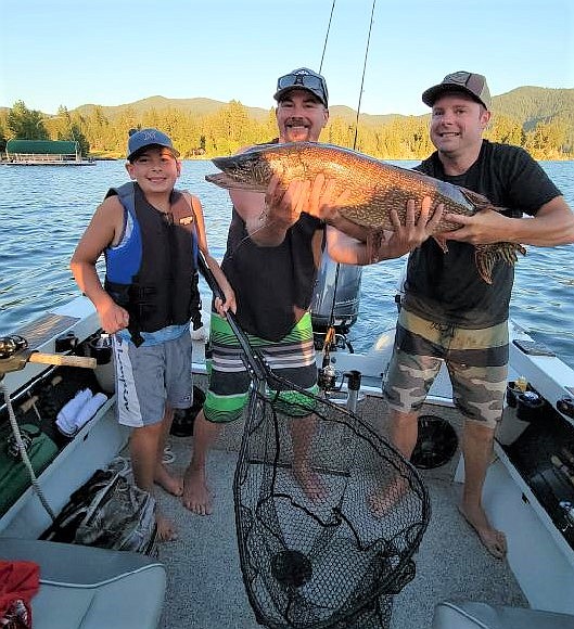 Photo courtesy Charli Inman
Tucker Inman-Melius, 10, shows off a big pike he recently pulled from Hayden Lake. He is joined by his uncle Levi Peterson, center, and his father, Ben Melius. The fish weighed about 20 pounds.