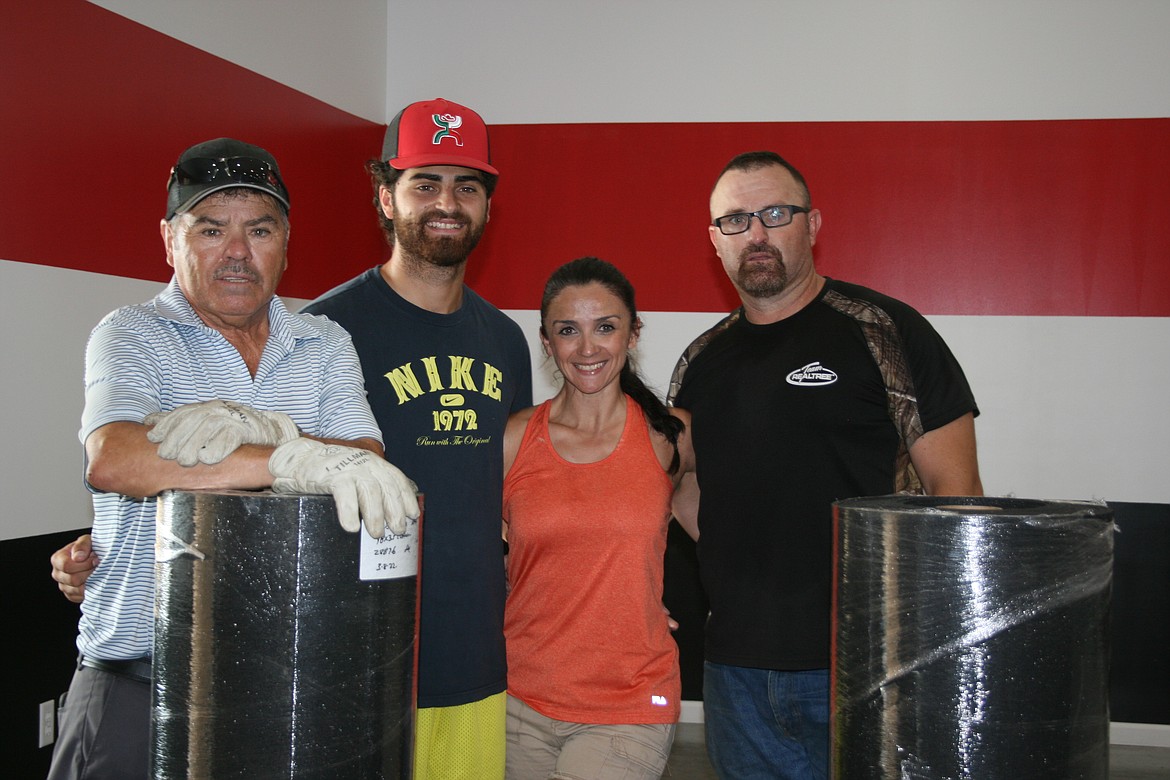 Family members (from left) Oscar, Jonathan II, Elizabeth and Jonathan Garza take a break from laying flooring at Jab Fitness in Othello.