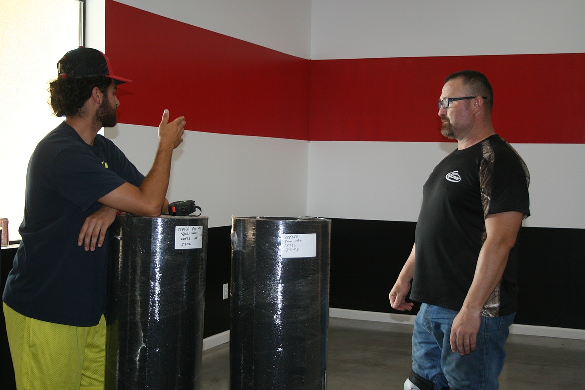Jonathan Garza (right) and his son Jonathan Garza II discuss the layout of cardio equipment at Jab Fitness.