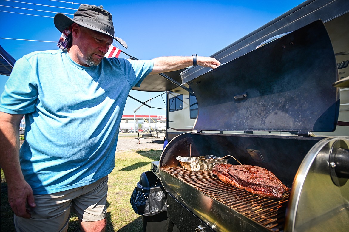 Gregg Hultquist with the team Holy Smokers checks his brisket cooking on a Recteq RT-700  at the Knights of Columbus Brisket Showdown at the Flathead County Fairgrounds on Saturday, July 30. (Casey Kreider/Daily Inter Lake)