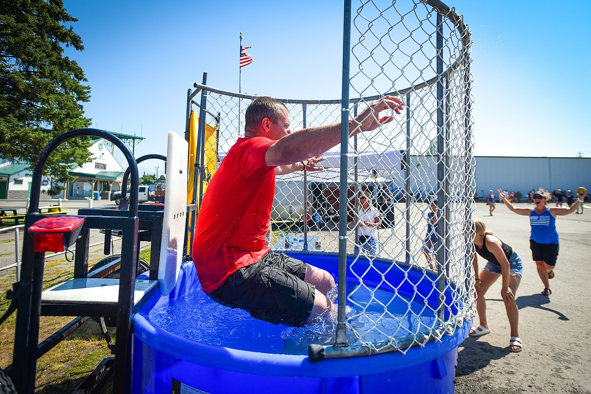 Flathead County Sheriff Brian Heino splashes into the dunk tank at the Knights of Columbus Brisket Showdown at the Flathead County Fairgrounds on Saturday, July 30. (Casey Kreider/Daily Inter Lake)