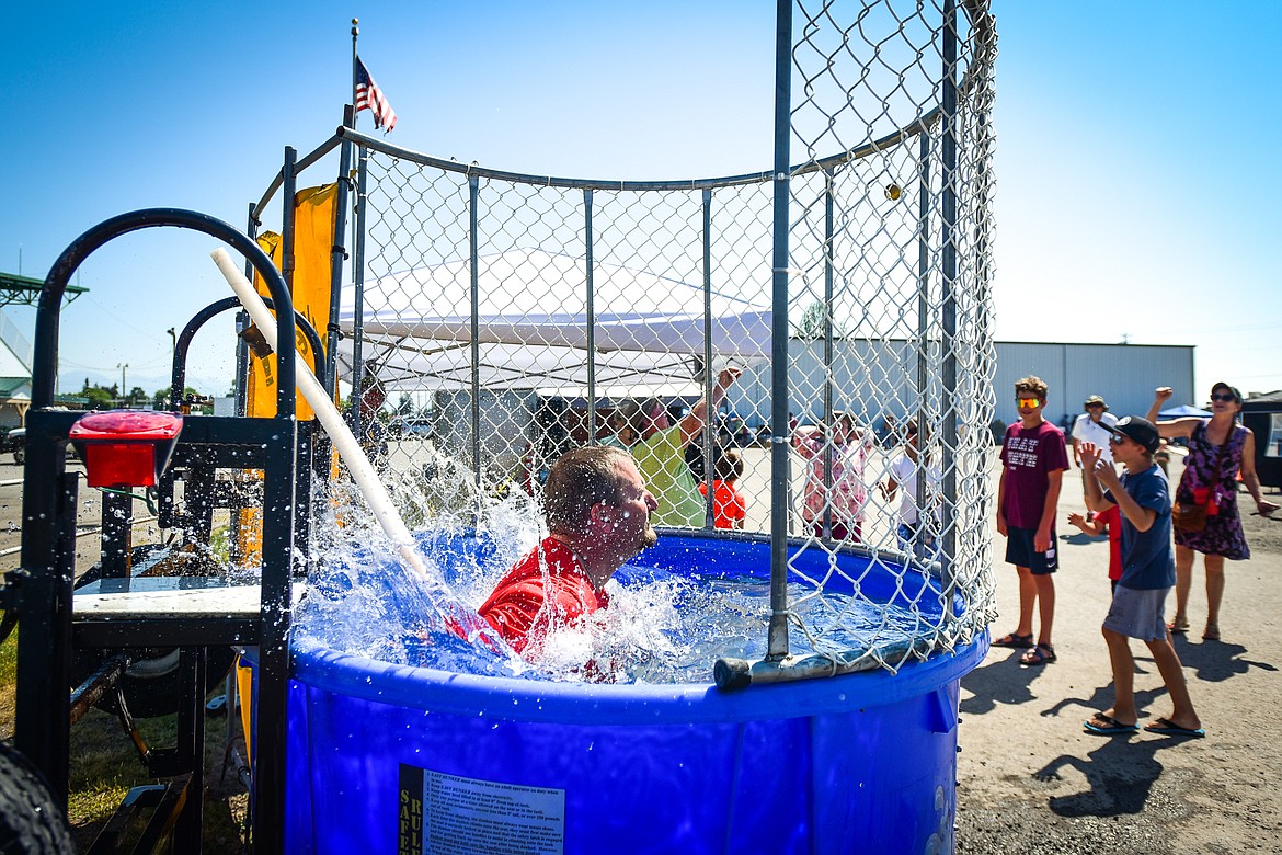 Flathead County Sheriff Brian Heino splashes into the dunk tank at the Knights of Columbus Brisket Showdown at the Flathead County Fairgrounds on Saturday, July 30. (Casey Kreider/Daily Inter Lake)