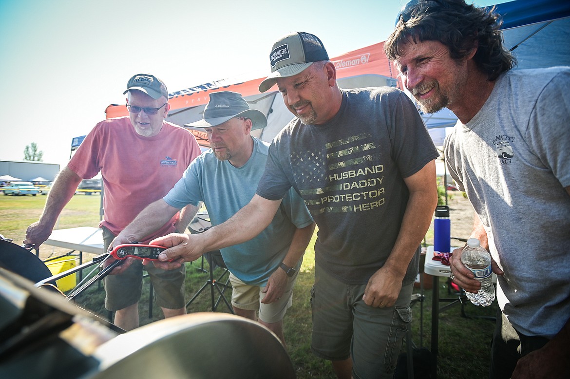 From left, Randy Flora, Gregg Hultquist, Duane Dierenfield and Bret Bullock check on their brisket cooking in a Recteq RT-700  at the Knights of Columbus Brisket Showdown at the Flathead County Fairgrounds on Saturday, July 30. (Casey Kreider/Daily Inter Lake)