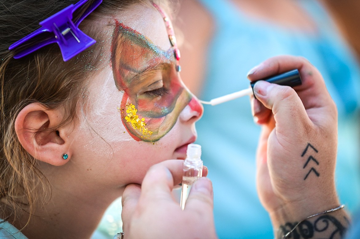Anna Holt has her face painted by Megan Payte-Reeves at the Knights of Columbus Brisket Showdown at the Flathead County Fairgrounds on Saturday, July 30. (Casey Kreider/Daily Inter Lake)