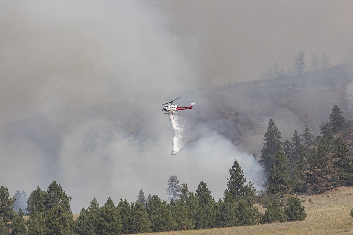 A helicopter drop water on the Elmo Fire burning west of Flathead Lake near Elmo on Saturday, July 30, 2022. (Rob Zolman/Lake County Leader)