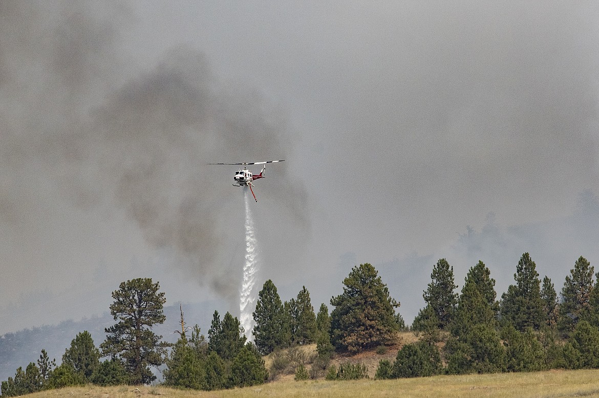 A helicopter drop water on the Elmo Fire burning west of Flathead Lake near Elmo on Saturday, July 30, 2022. (Rob Zolman/Lake County Leader)