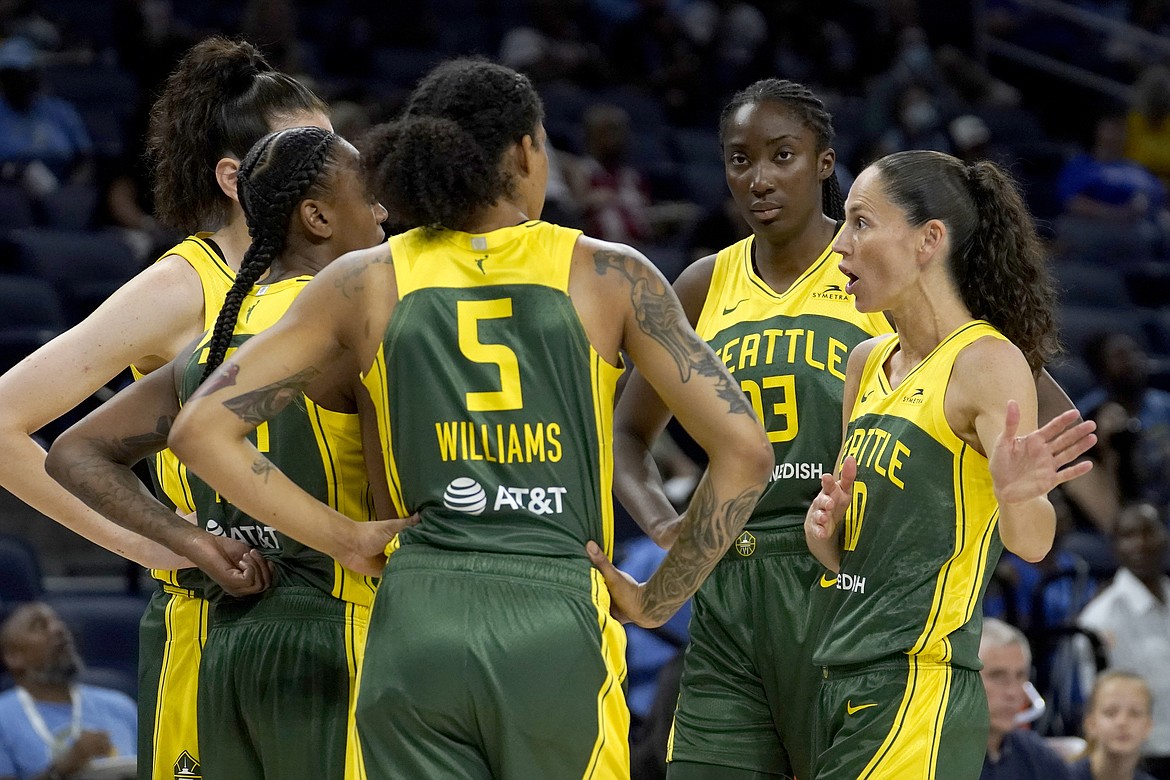 Seattle Storm's Sue Bird, right, talks with her teammates during a break in the first half of their WNBA basketball game against the Chicago Sky Wednesday, July 20, 2022, in Chicago. About a week later, the Storm went on to defeat the Mystics.